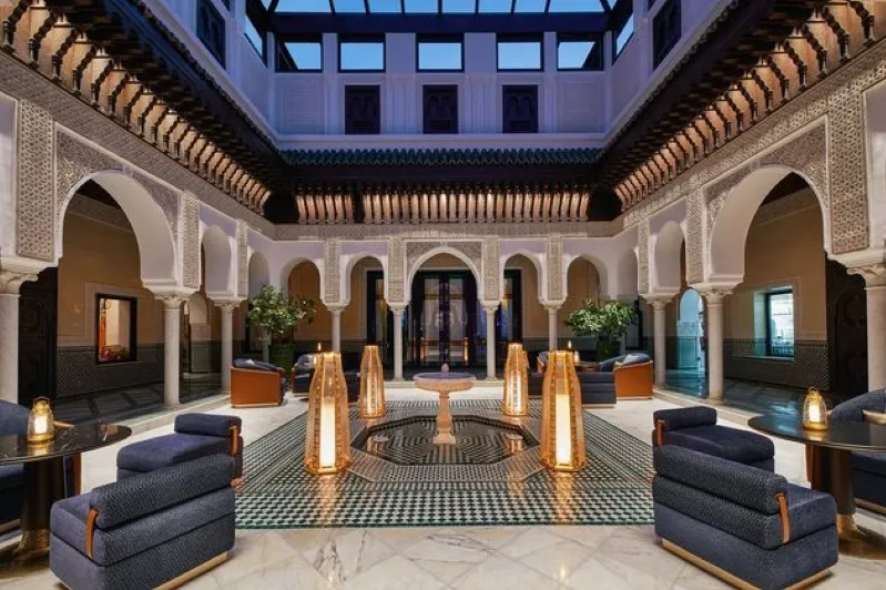 A luxurious hotel lobby in Morocco featuring an elegant fountain and comfortable seating arrangements.