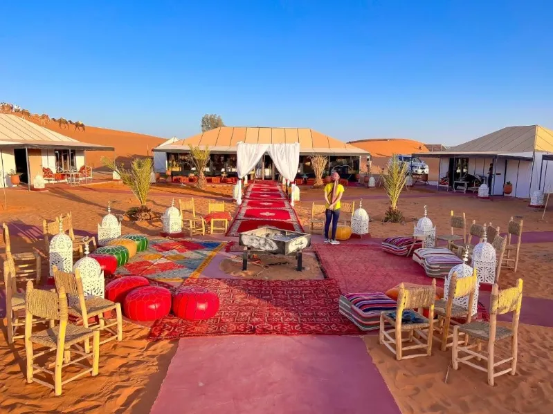 A spacious tent and chairs at a morocco desert camp, nestled in the serene expanse of the desert.