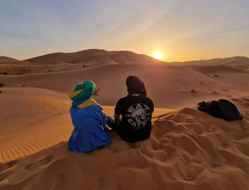 A breathtaking sunset over the Sahara Desert, showcasing vibrant colors and vast dunes, perfect for Fes desert tours. 