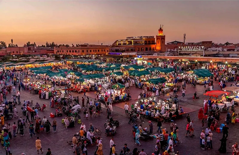 Marrakech at sunset, with warm colors illuminating the city, an enchanting sight for those on Morocco travel tours.