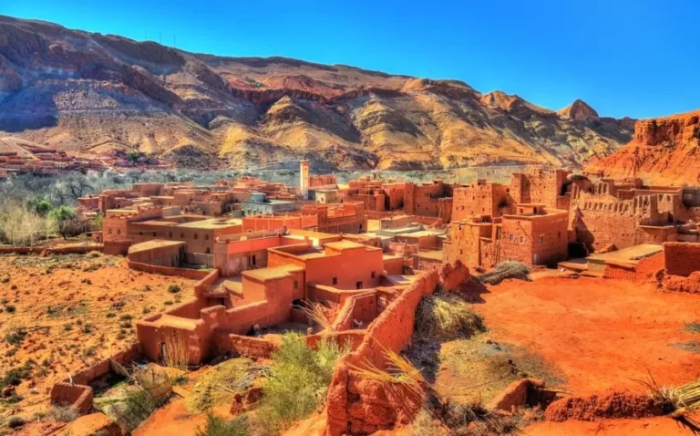 A picturesque Moroccan village nestled in the desert, showcasing traditional architecture under a clear blue sky.