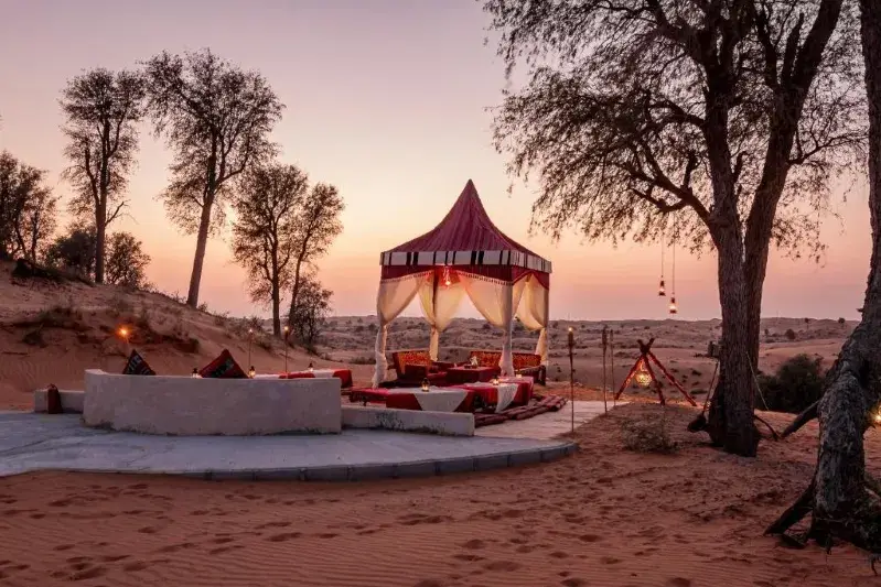 A stylish tent featuring a red canopy in the Moroccan desert, representing the allure of luxury desert tours.