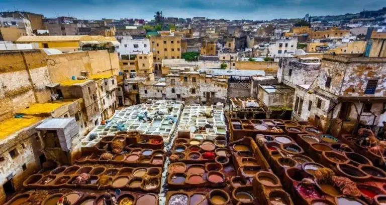 A vibrant display of colorful pots and pans in a bustling Moroccan city, showcasing the rich culture of Family Morocco Tours.