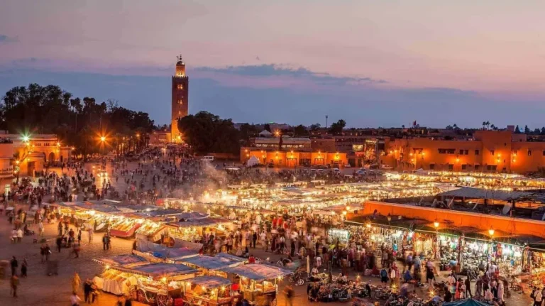 Marrakech at dusk, with its enchanting skyline and warm hues, inviting visitors to explore its rich culture on city tours.