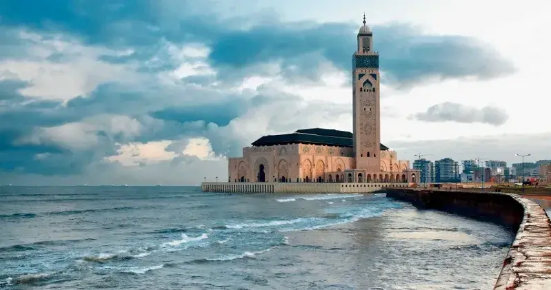  A majestic mosque by the ocean, highlighting its grandeur, featured in the Imperial Cities Tours of Morocco.