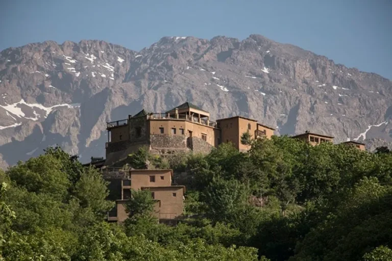 A mountain-top building surrounded by trees, showcasing stunning views, ideal for travelers seeking Morocco travel deals.