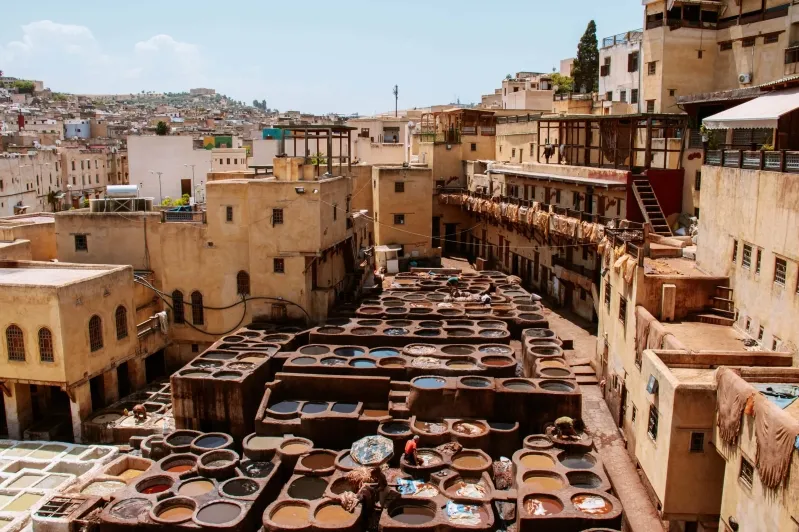 A vibrant street in Morocco showcasing an array of colorful pots and pans, highlighting the local craftsmanship and culture.