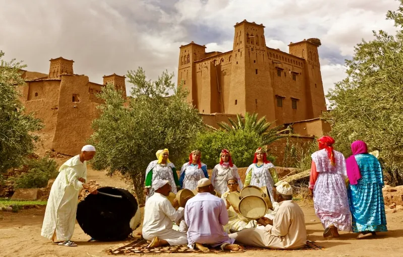 A group of individuals in traditional Moroccan attire playing drums, showcasing cultural music and dance.