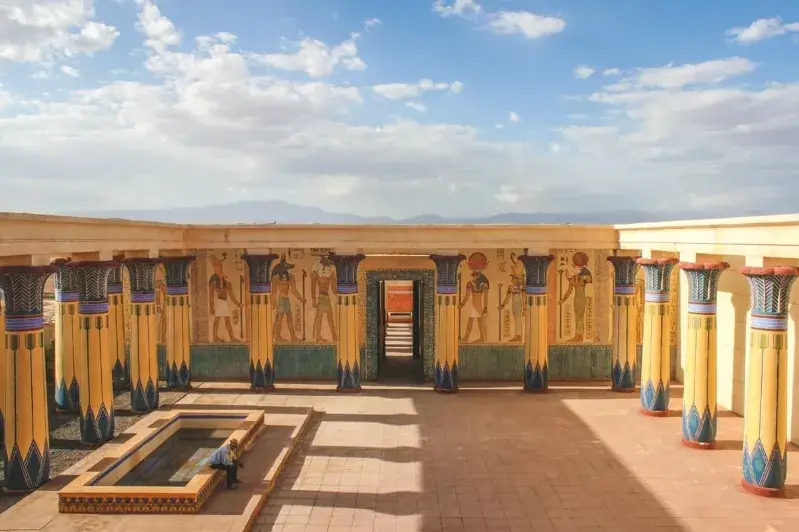Interior of temple featuring ornate columns and vibrant paintings, showcasing ancient artistry and architecture.