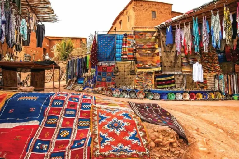 A vibrant market scene showcasing an array of colorful rugs and various items, reflecting the essence of Ouarzazate.