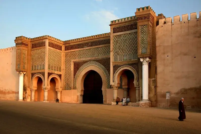 The entrance to Marrakesh, showcasing vibrant architecture and bustling activity, a gateway to the journey to Ouarzazate.
