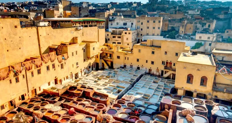 A vibrant Moroccan city scene showcasing numerous colorful pots and barrels, ideal for small group tours. 