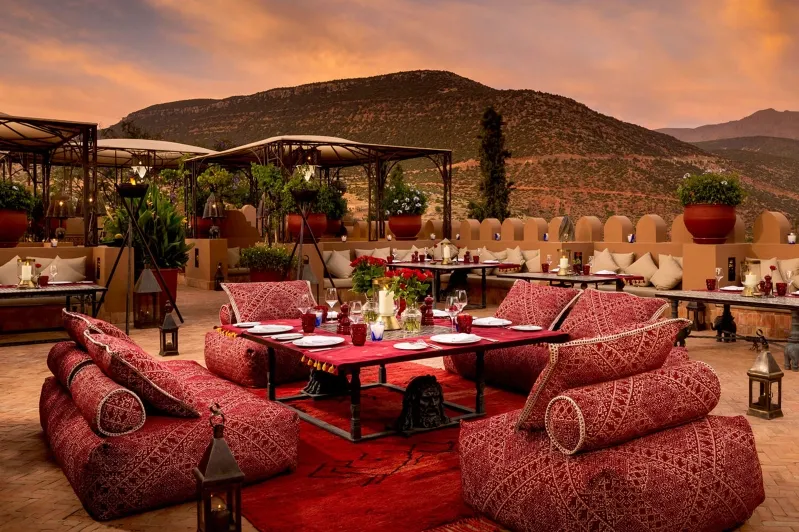 A patio restaurant featuring red couches and tables, ideal for small group luxury tours in Morocco. 