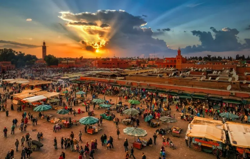 Sunset casting vibrant colors over the cityscape of Marrakech, highlighting its unique architecture and charm.Morocco Tourist Spots 