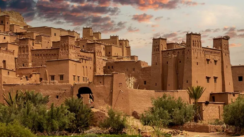 A scenic depiction of a Moroccan city amidst the desert, showcasing its unique architecture and tourist spots. 