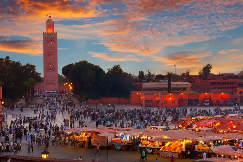 Sunset over Marrakech, Morocco, showcasing vibrant colors and silhouettes, a highlight for top tour operating Morocco agencies.