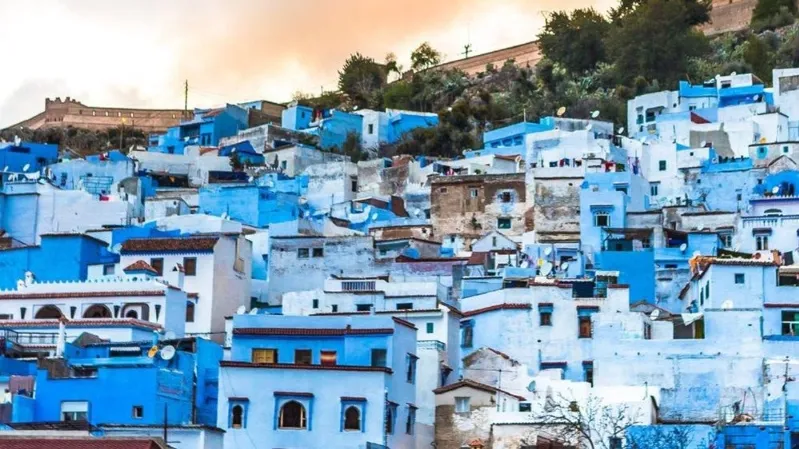 Scenic view of Chefchaouen, Morocco, showcasing its iconic blue buildings and mountainous backdrop, popular for travelers.Trips to Casablanca Morocco