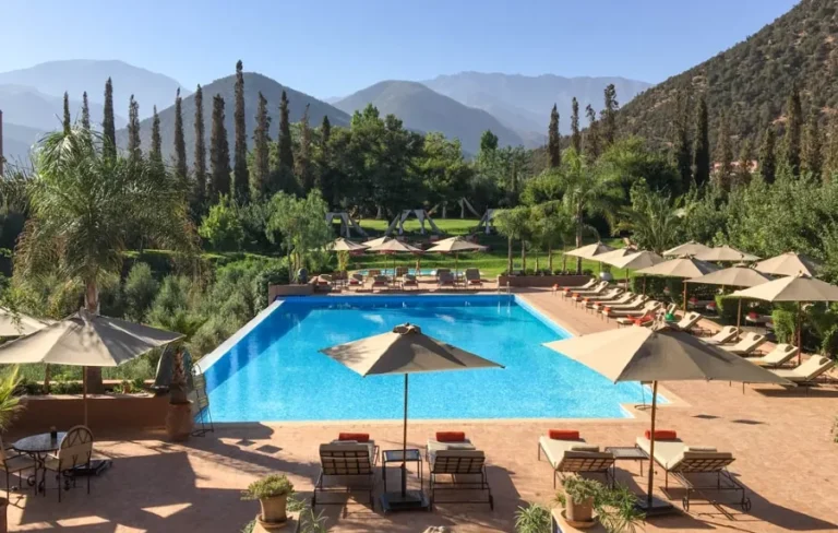 A serene pool area with lounge chairs and umbrellas, ideal for relaxation during small group tours of Morocco.