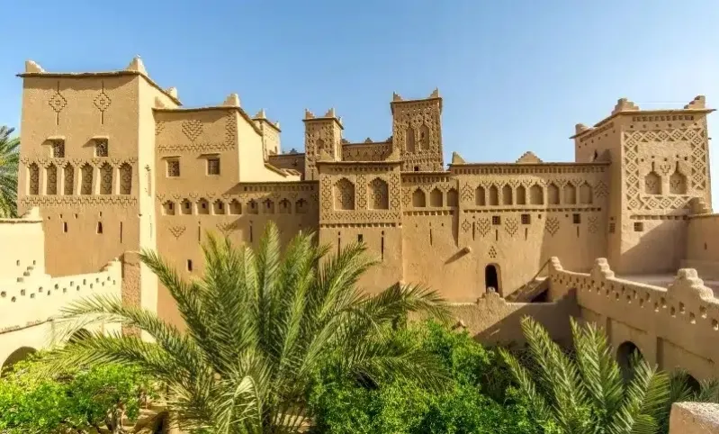 The grand palace of the Sultan of Morocco, showcasing traditional architecture and surrounded by Moroccan people. 