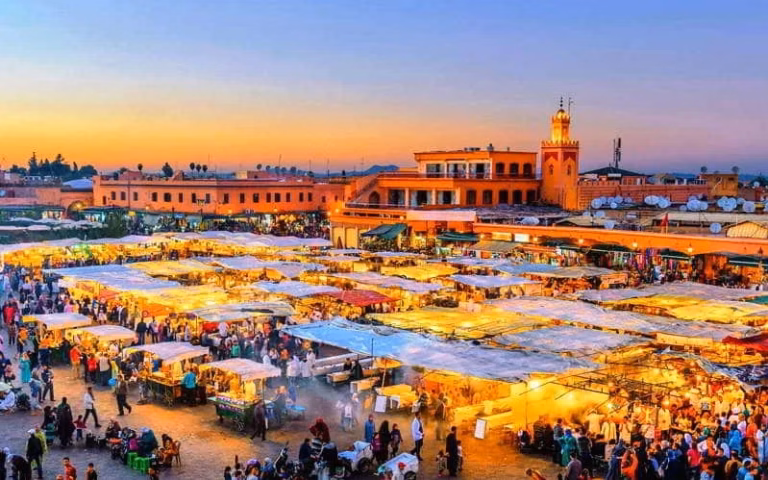 A stunning sunset casts warm hues over Marrakech, highlighting its unique skyline, perfect for Morocco travel enthusiasts.