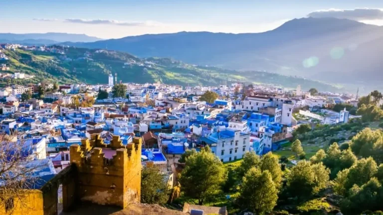 A panoramic view of the blue city of Chefchaouen, Morocco, showcasing its vibrant blue buildings and scenic mountains.