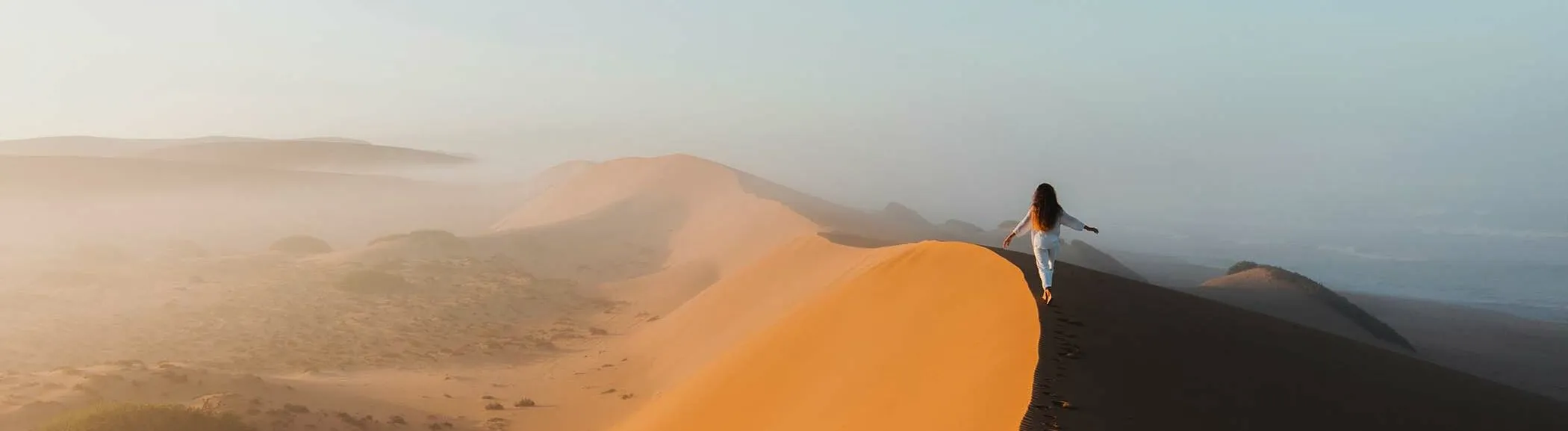 Travelers exploring the Moroccan Sahara Desert on a 7-day private tour from Casablanca with camel trekking and desert camp experience