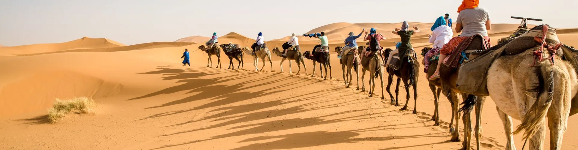 Luxury desert camp in Merzouga, Morocco with elegant tents surrounded by the golden dunes of the Sahara Desert