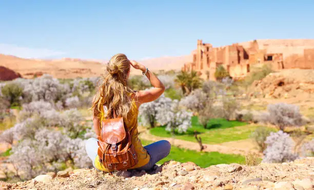 Traveler woman exploring Morocco medina streets, wearing traditional scenery, walking in Marrakech souks and desert landscapes